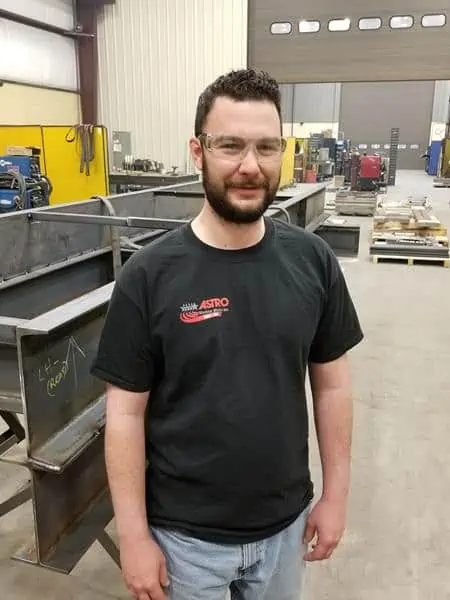 Astro Employee Austin Jones smiling for picture inside Astro facility